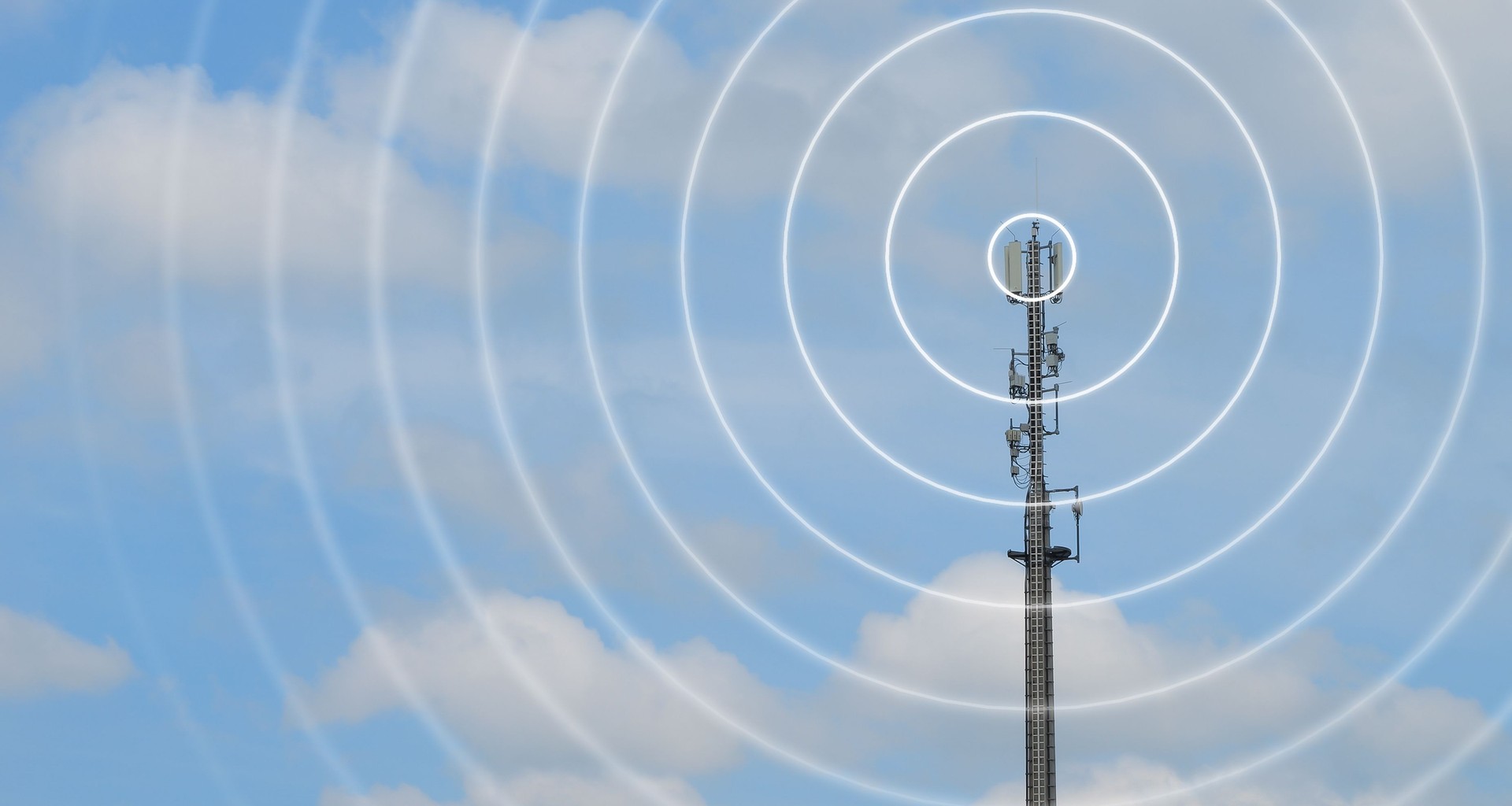 antenna tower as phone base station  with radio waves isolated on cloudy sky background, concept with copy space for wireless and mobile communication, tv and internet