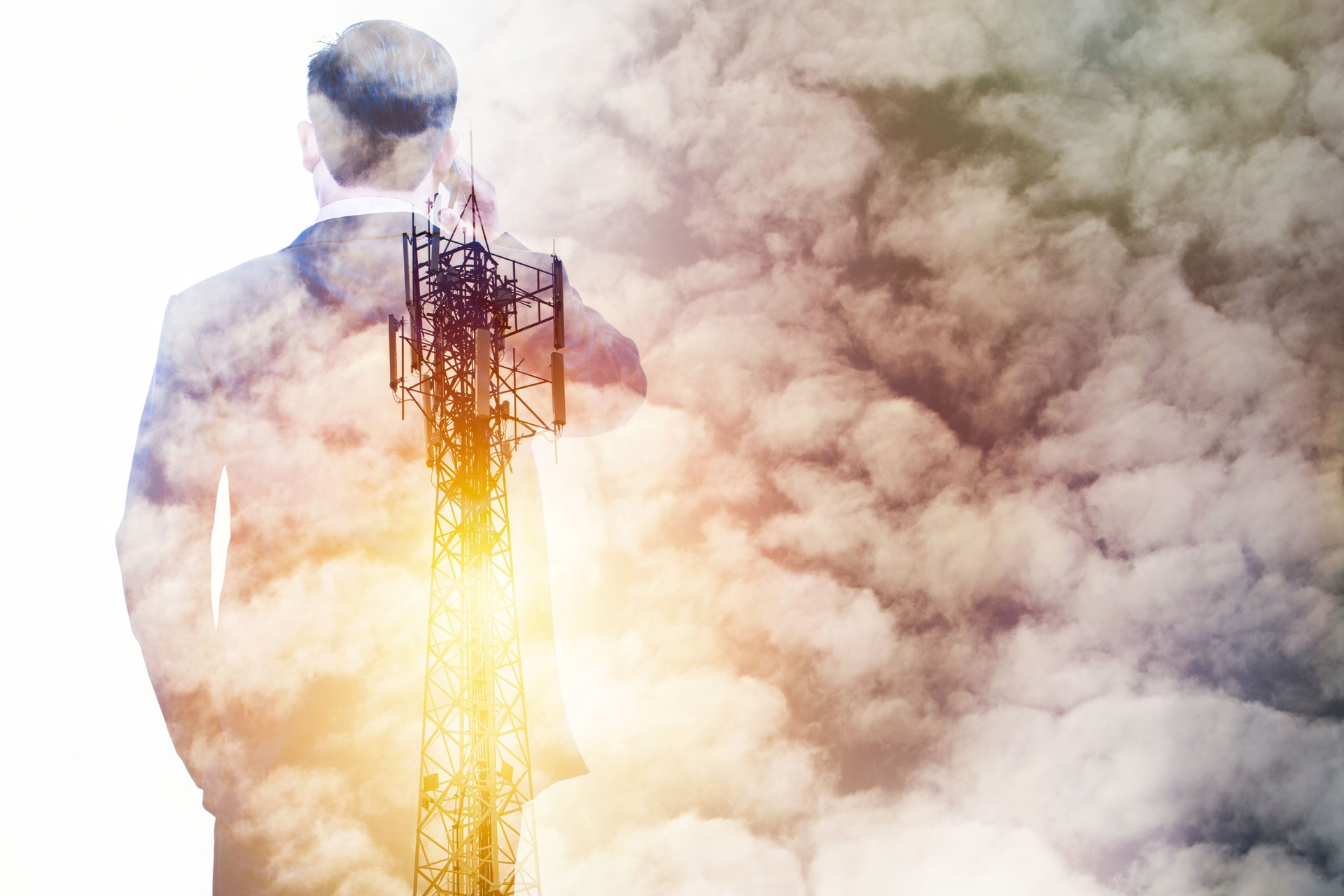 Double exposure business man using phone with cell tower and white cloud, communication business concept